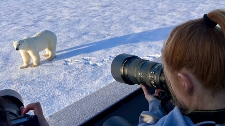 A Kelvin student taking photo of a Polar Bear in Churchill.