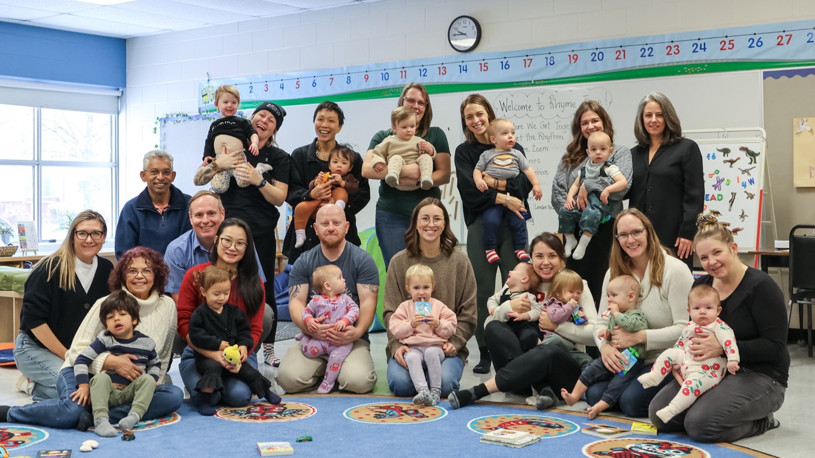 Parents with their children and École Riverview School staff at the Rhyme Time event.