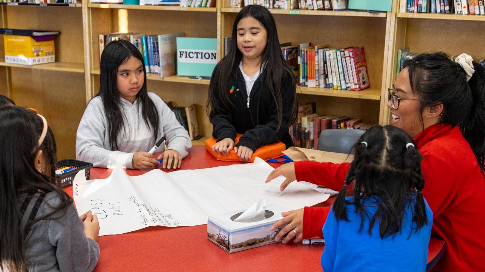 Students draft together a set of rules in English that they will translate into Tagalog. One of the student’s mother, Emmeline, helps them.