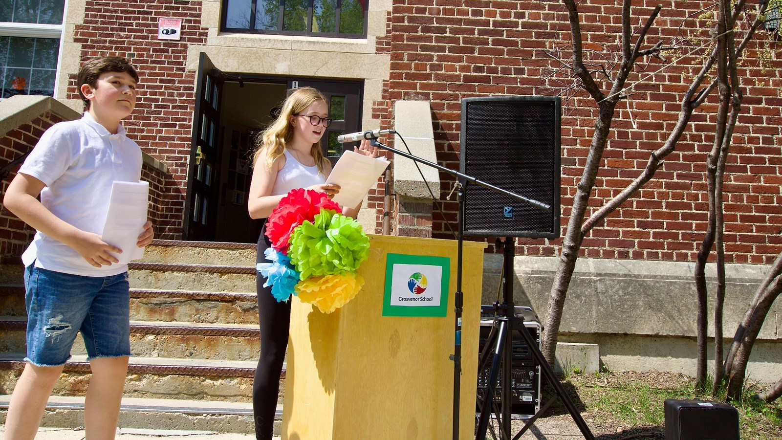 Students at podium in front of Grosvenor School
