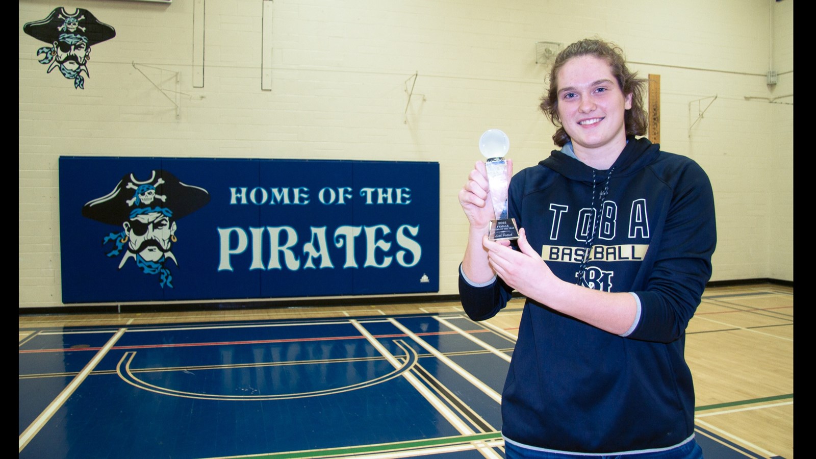 Leah showcasing her Baseball of the Year Award in the Gym